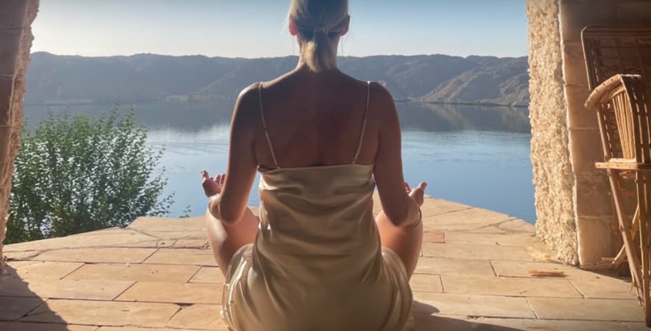 Michaela in meditation overlooking a lake